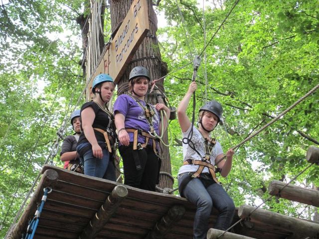 Jugendliche auf eine Plattform im Kletterwald