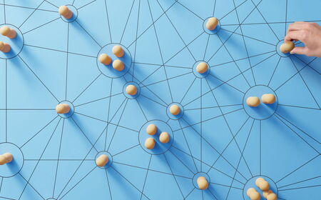Darstellung eines Netzwerks von Menschen anhand von Holzfiguren auf blauem Grund 