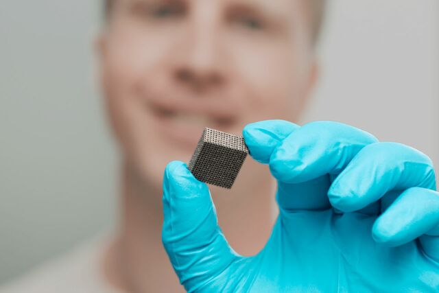 Ein Mann hält mit einem Handschuh Magnetokalorisches Material