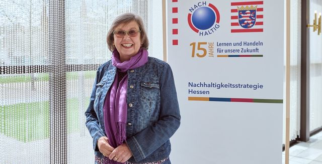 Das Bild zeigt Sigrid Isser vor einem NHS-Banner.