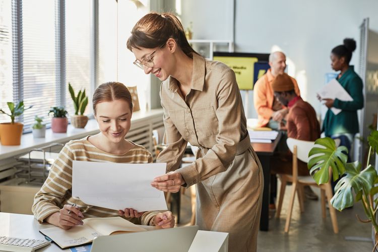 Zwei Frauen diskutieren Dokumente im Amt