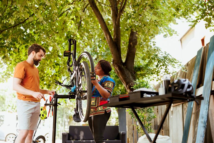 Fahrradreparatur: Zwei Menschen zwischen denen ein umgedrehtes Fahrrad und Werkzeug steht