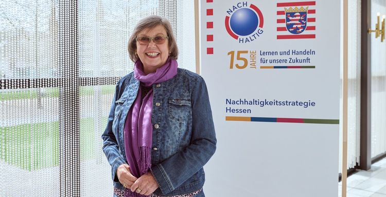 Das Bild zeigt Sigrid Isser vor einem NHS-Banner.