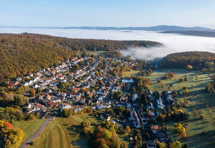 Luftaufnahme eines kleinen Dorfes im Taunus mit Morgennebel über dem Tal © istockphoto.com/Harald007