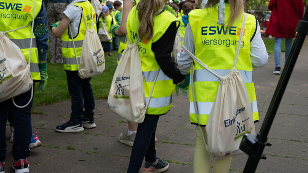 Menschen in Warnwesten sammeln Müll auf