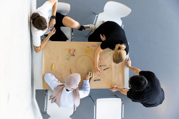 Studenten arbeiten an einem Tisch zusammen
