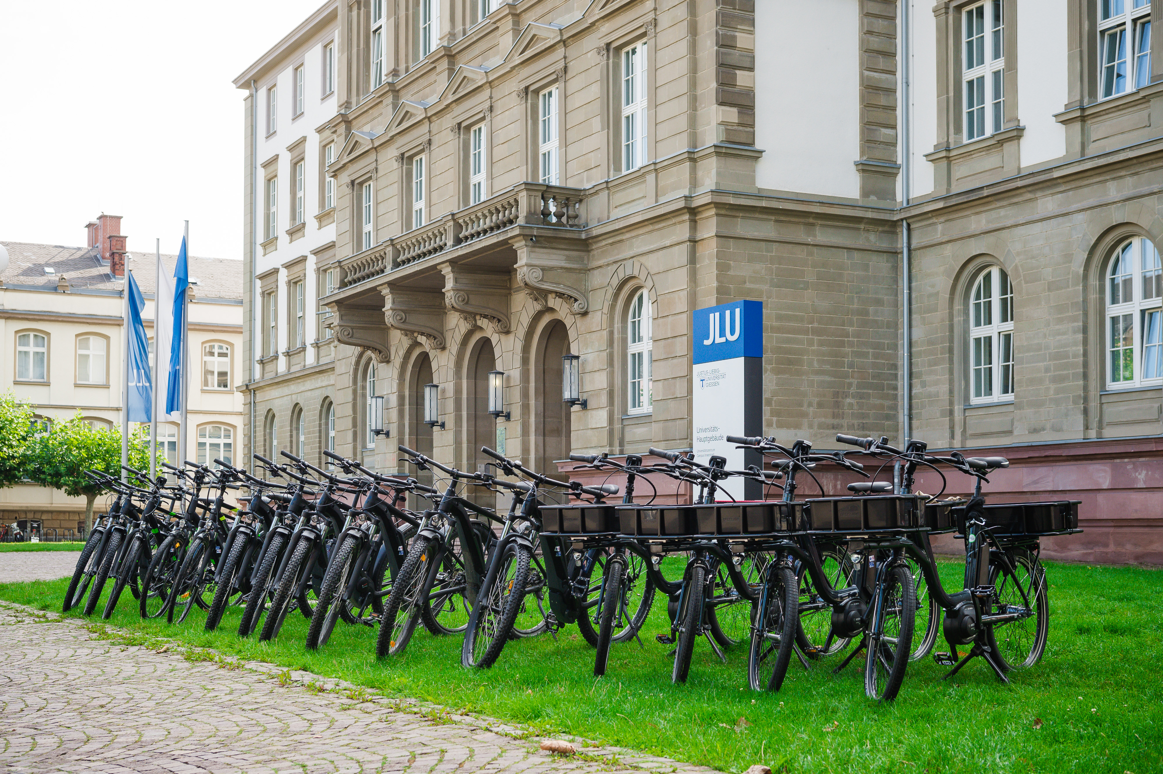 Mehrere Pedelecs stehen vor einem Gebäude der Justus-Liebig-Universität Gießen